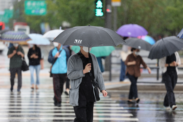 가을비가 내린 지난달 30일 서울 광화문사거리에서 긴팔옷을 입은 시민이 우산을 쓰고 이동하고 있다. 연합뉴스