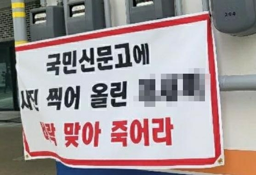 주차위반으로 신고 당한 차주가 게시한 현수막. 연합뉴스