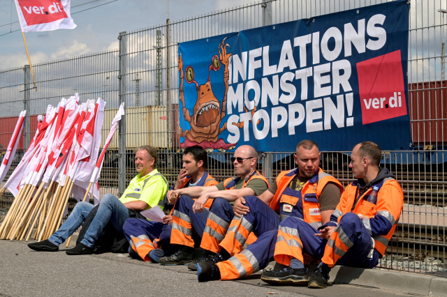 독일 함부르크에서 ‘인플레이션 괴물을 멈춰라’라는 현수막 아래에서 근로자들이 휴식을 취하고 있다.로이터연합뉴스