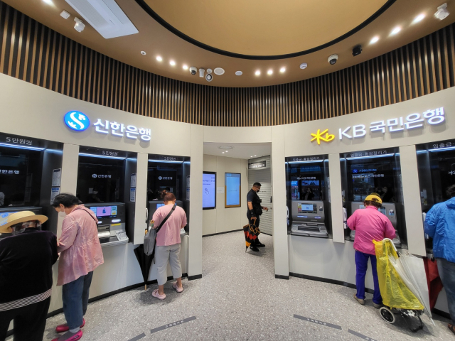 5일 문을 연 국민·신한은행 양주고읍 공동점포 1층에 설치된 ATM을 고객들이 이용하고 있다. 양 은행의 ATM이 각각 3대씩 총 6대가 설치돼 있다.