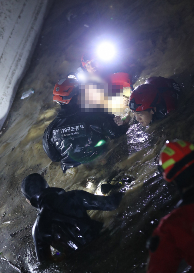 6일 저녁 태풍 힌남노의 폭우로 잠긴 경북 포항시 남구의 한 아파트 지하 주차장에서 소방·군 관계자들이 주민 1명을 구조하고 있다. 포항=연합뉴스