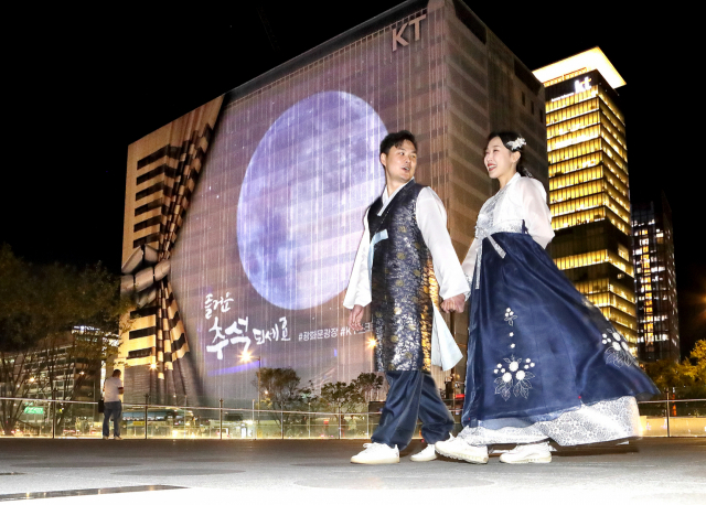 KT 모델이 광화문광장에서 초대형 보름달을 관람하고 있다. 사진제공=KT