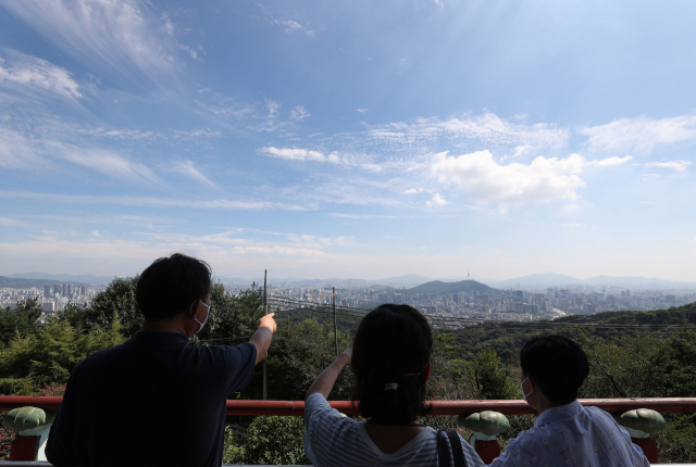 지난 1일 오후 서울 종로구 북악 팔각정을 찾은 한 가족이 서울 시내를 바라보고 있다. 연합뉴스