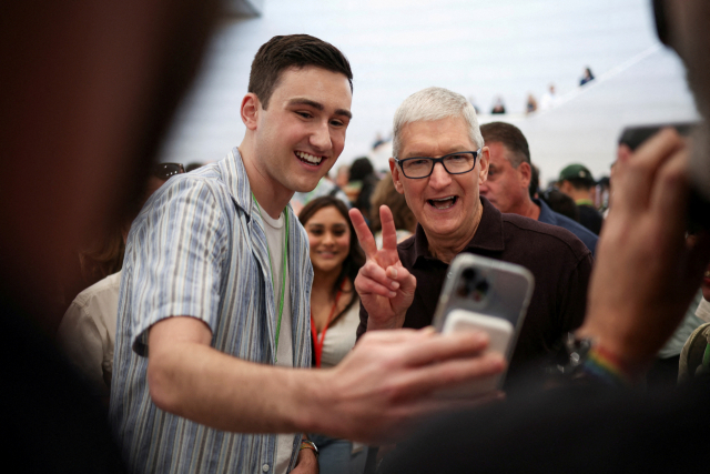 팀 쿡(오른쪽) 애플 최고경영자(CEO)가 7일(현지시간) 미국 캘리포니아주 쿠퍼티노의 애플 본사에서 열린 신제품 공개 행사에서 한 참석자와 함께 셀카를 찍고 있다. 연합뉴스