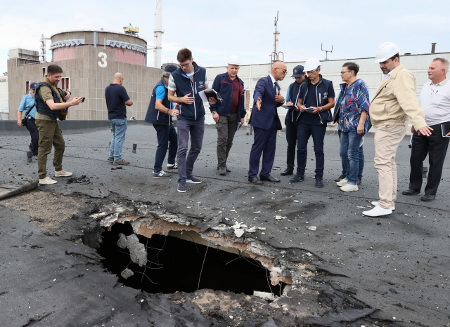 1일(현지 시간) 라파엘 그로시(오른쪽 네 번째) 국제원자력기구(IAEA) 사무총장이 이끄는 사찰단이 우크라이나 자포리자 원자력발전소에 방문해 포격으로 파손된 도로 지면을 살펴보고 있다. /타스연합뉴스