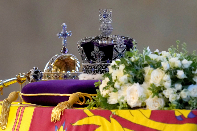 16일 엘리자베스 2세 여왕 관 위에 영국 왕실을 상징하는 왕관과 지팡이 모양의 홀이 놓여 있다. 로이터연합뉴스