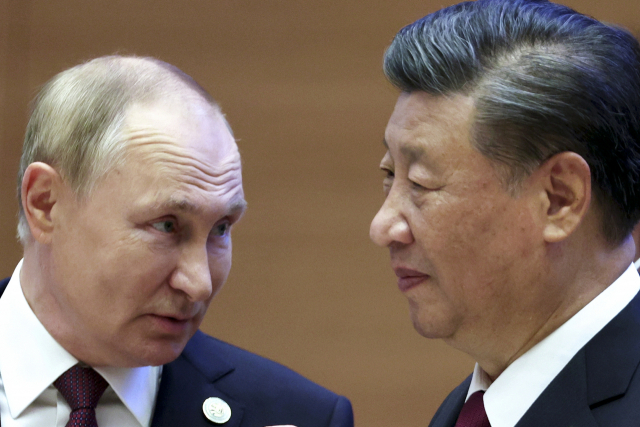 블라디미르 푸틴(왼쪽) 러시아 대통령과 시진핑 중국 국가주석이 16일(현지 시간) 우즈베키스탄 사마르칸트에서 개최된 상하이협력기구(SCO) 정상회의에 참석한 자리에서 서로 대화하고 있다. AP연합뉴스