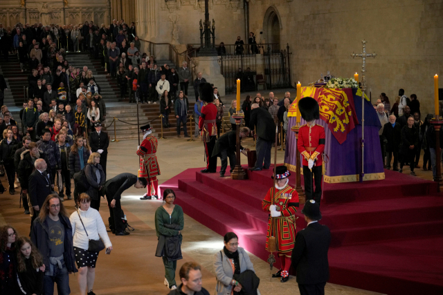 영국 시민들이 18일(현지시간) 런던 웨스트민스터 홀에 안치된 엘리자베스 2세 여왕의 관 앞에서 참배하고 있다. 로이터연합뉴스