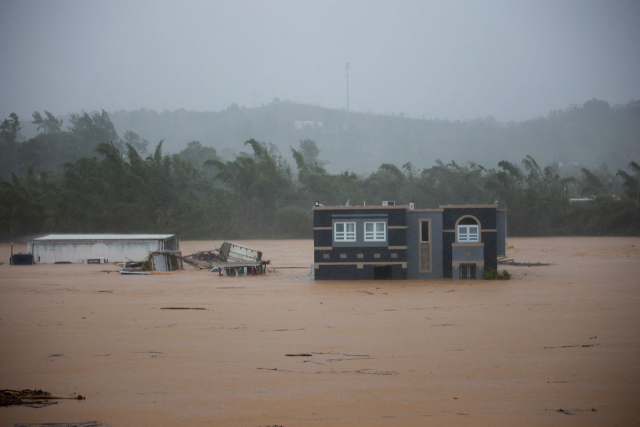 18일(현지 시간) 푸에르토리코 카예이 지역에서 발생한 홍수로 가옥이 범람한 강물에 잠겨있다.AP연합뉴스