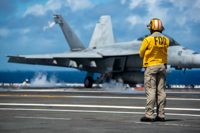 미 해군 소속 핵항공모함 로널드 레이건호에서 승조원이 F/A-18F 슈퍼호넷을 바라보는 모습. /사진제공=미 국방부