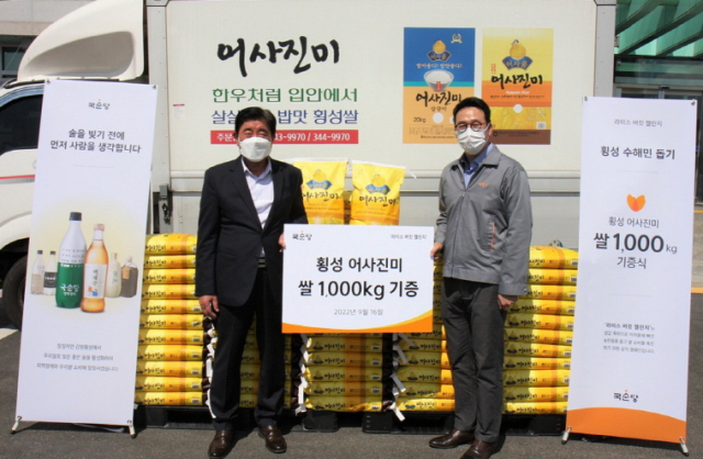 국순당 배상민 대표(오른쪽)가 '라이스 버킷 챌린지'를 통해 구매한 국산 쌀 1톤을 김명구 횡성군수에게 전달하고 기념촬영을 하고 있다. /사진 제공=국순당