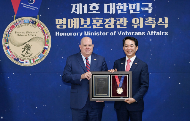 국가보훈처가 19일 서울 용산구 서울지방보훈청에서 래리 호건 미국 메릴랜드주지사를 제1호 ‘대한민국 명예보훈장관’으로 위촉했다. 박민식(오른쪽) 국가보훈처장과 호건 주지사가 이날 서울지방보훈청 호국홀에서 열린 위촉식에서 기념 메달을 들고 포즈를 취하고 있다. 권욱 기자