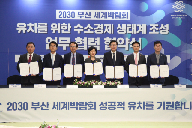 19일 부산시청에서 열린 ‘2030 부산 세계박람회 유치 지원을 위한 수소경제 생태계 조성 업무협약’ 체결식에서 추형욱(오른쪽 두번째) SK E&S 대표이사 사장이 한화진 환경부 장관, 박형준 부산시장, 강준석 부산항만공사 사장, 김동욱 현대자동차 부사장, 김형균 부산테크노파크 원장, 성현도 부산버스운송조합 이사장과 기념 촬영을 하고 있다. / 사진제공=SK E&S