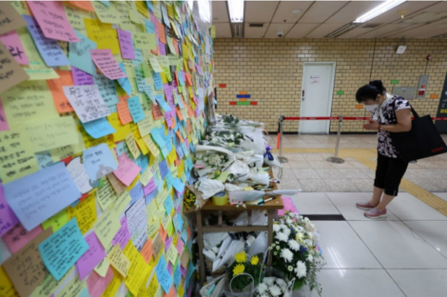 서울 지하철 2호선 신당역 여자화장실 입구에 마련된 추모공간에서 19일 한 시민이 피해자를 추모하고 있다.연합뉴스