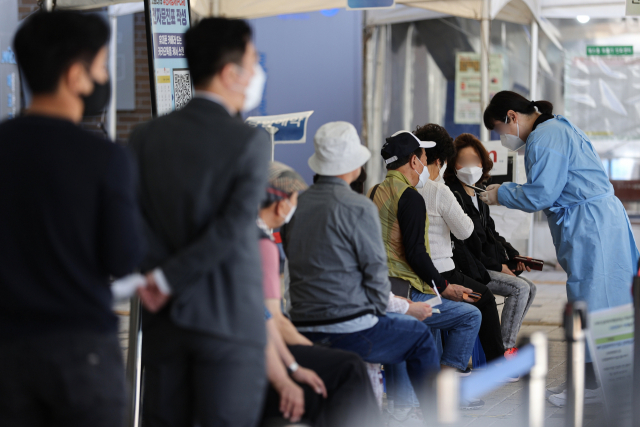 코로나19 재유행 감소세가 이어지는 가운데 20일 시민들이 서울 마포구 보건소에 마련된 선별진료소에서 검사를 기다리고 있다. /연합뉴스