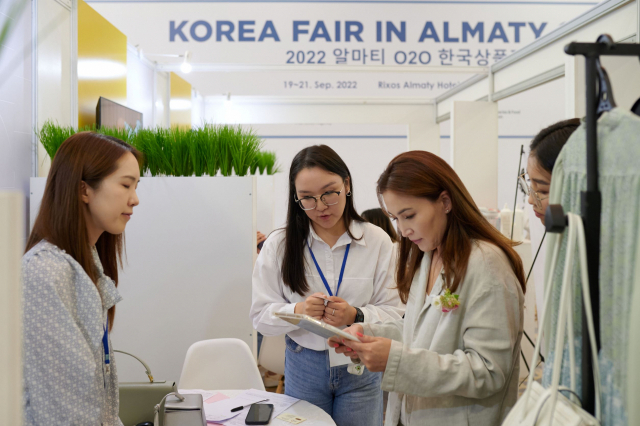 KOTRA가 지난 19~21일 카자흐스탄에서 개최한 한국우수상품전에 참가한 한 방문객이 제품 설명을 듣고 있다. 사진제공=KOTRA