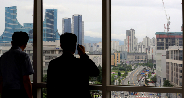 정부세종청사에서 공무원들이 세종 시내 아파트를 바라보고 있다/연합뉴스