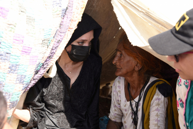 앤젤리나 졸리(왼쪽)가 20일(현지시간) 홍수 피해를 본 파키스탄의 한 마을을 찾아 이재민의 이야기를 듣고 있다. 로이터=연합뉴스