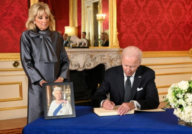 조 바이든 미국 대통령이 지난 18일 런던 랭커스터 하우스에서 엘리자베스 2세 여왕의 조문록을 작성하고 있다. 왼쪽은 질 바이든 영부인. 로이터 연합뉴스