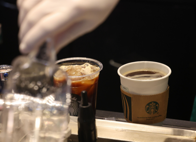 주요 커피전문점과 패스트푸드점에서 한해 소비되는 일회용컵이 증가하는 가운데 13일 서울의 한 커피 전문점에서 직원이 일회용 컵에 커피를 포장하고 있는 모습.연합뉴스