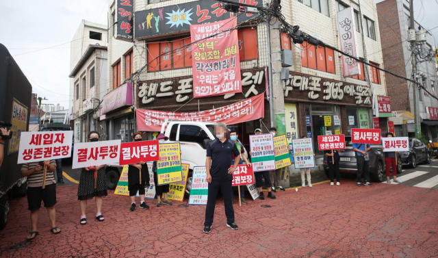 광주 남구 장미아파트 인근에서 상가 세입자들이 재건축조합이 신청한 법원의 강제 집행에 반발하며 구호를 외치고 있다./연합뉴스