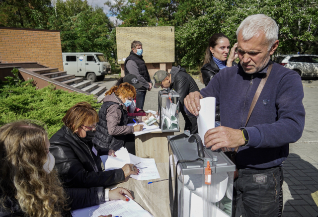 25일(현지 시간) 우크라이나 동부 마리우폴의 한 야외 투표소에서 지역합병 주민투표가 진행되고 있다.EPA연합뉴스