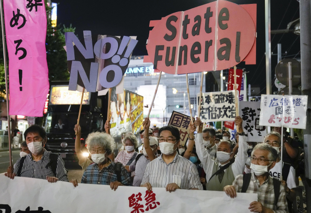16일 일본 도쿄 시내에 모인 시위대가 암살당한 아베 신조 전 총리의 국장 거행에 반대하는 팻말을 들고 있다. EPA연합뉴스