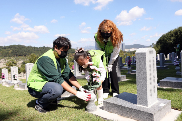현대엔지니어링 임직원과 가족들이 24일 서울시 동작구 국립서울현충원에서 묘역 정화 봉사활동을 하고 있다. 사진제공=현대엔지니어링