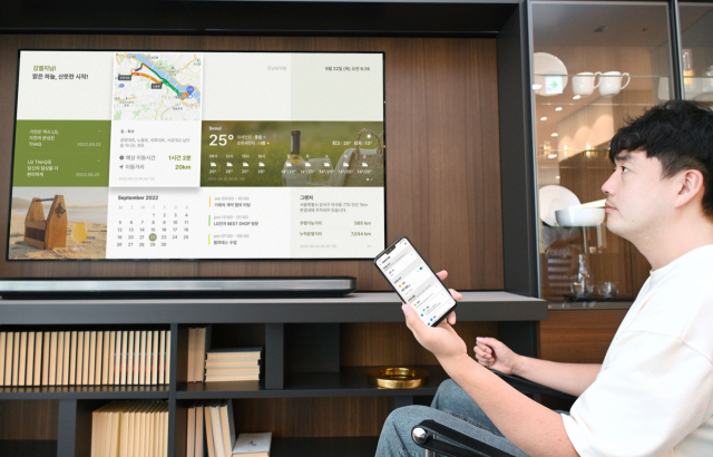 LG전자 모델이 LG 씽큐 앱 '모닝브리핑' 서비스를 실행해 TV 화면에서 날씨·교통 등의 정보를 확인하고 있다. 사진제공=-LG전자
