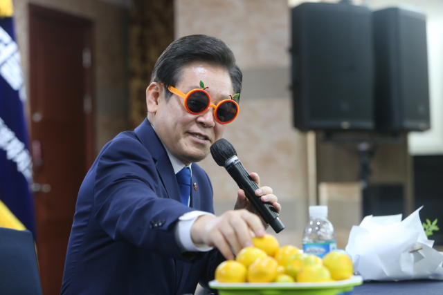 이재명 더불어민주당 대표가 감귤 선글라스를 끼고 제주 감귤을 들어 보이고 있다. 연합뉴스