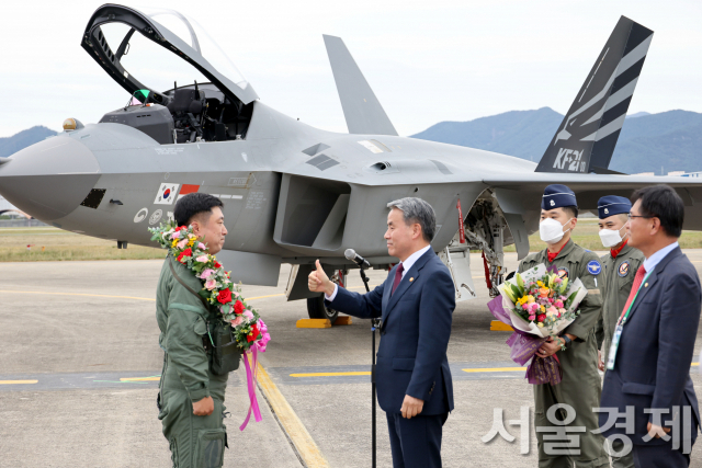 이종섭 국방부 장관이 28일 경남 사천 공군 제 3훈련비행단 활주로에서 국산 전투기 KF-21보라매를 몰고 19분간의 첫 공개 시험비행을 무사히 마친 제 52시험평가전대 소속 안준현 중령(진)에게 화한을 걸어주며 격려하고 있다. 사진제공=방사청