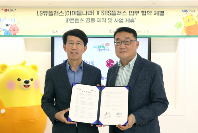 박종욱 LG유플러스 아이들나라CO(전무)와 이창태 SBS플러스 대표가 업무협약서를 들어보이고 있다. 사진제공=LG유플러스