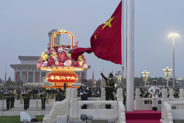 중국 의장대가 1일 베이징 천안문 광장에서 열린 중화인민공화국 건국 73주년 국기 게양식에서 중국 국기를 펴고 있다. 신화연합.