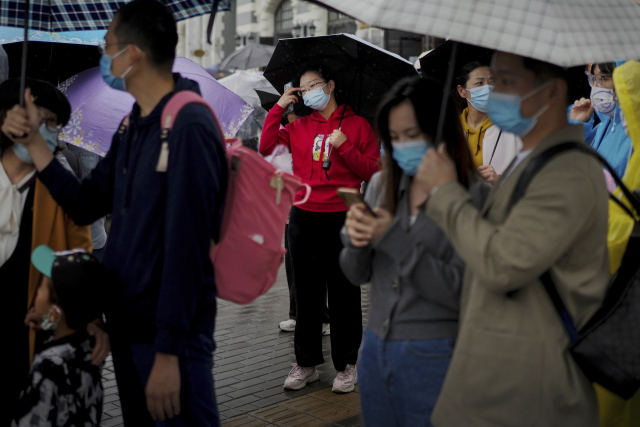 3일 국경절 연휴를 맞아 관광객들이 우산을 쓰고 마스크를 착용한 채 베이징 톈안먼광장을 지나고 있다. 하반기 최대 연휴인 국경절 연휴에도 강력한 제로 코로나 정책의 영향으로 중국의 여행 수요는 예년에 비해 크게 줄어든 모습이다. AP연합뉴스