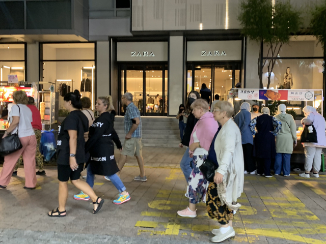 서울 명동 거리에서 히잡을 쓴 외국인들이 노점에서 크로와상을 구경하고 있다. 옆으로 미국인 관광객들이 지나가고 있다. 김남명 기자