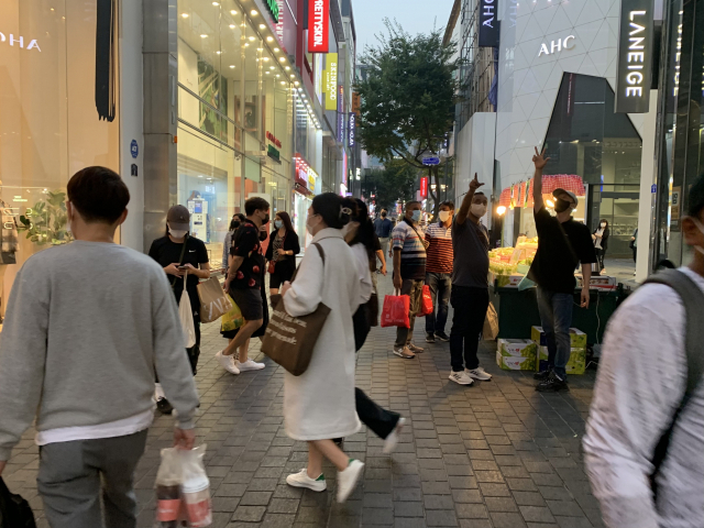 양 손에 쇼핑백을 든 외국인들이 서울 명동 거리를 지나가고 있다. 김남명 기자