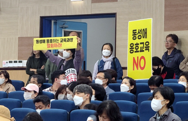 일부 참석자들이 8일 오후 한국교원대학교에서 교육부 주관 2022 개정 교육과정 총론 시안에 대한 공청회에서 '동성애 옹호하는 교육과정을 철회하라'는 등의 피켓을 들고 있다. 연합뉴스