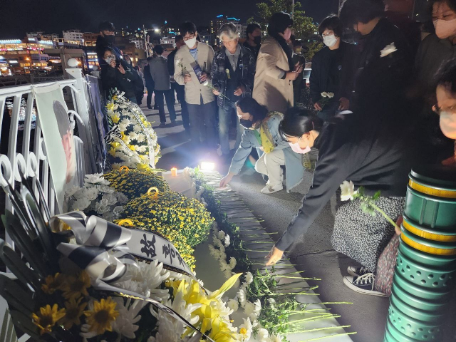 시민들이 6일 여수 웅천 요트선착장에 마련된 고 홍정운군의 사진 앞에 꽃을 놓고 있다. 사진제공=전국특성화고노조