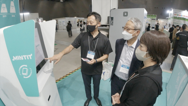 6~8일 일본 아이치현 국제전시장에서 열린 ‘SDGs 아이치 엑스포 2022’에서 현장 담당자가 SK네트웍스의 중고폰 매입 기기 ‘민팃(MINTIT)’의 기능을 설명하고 있다. 사진 제공=SK네트웍스