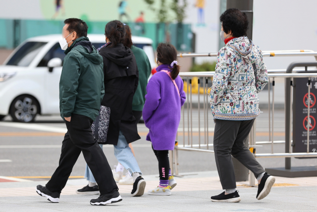 서울 아침 기온이 9도까지 떨어지며 쌀쌀한 날씨를 보인 10일 오전 시민들이 서울 종로구 광화문 광장에서 주머니에 손을 넣고 길을 건너고 있다. 연합뉴스