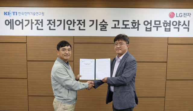 진심원(왼쪽) LG전자 에어솔루션연구소장이 이상범 한국전자기술연구원 광주지역본부장과 업무협약을 맺은 뒤 협약서를 들어보이고 있다.
