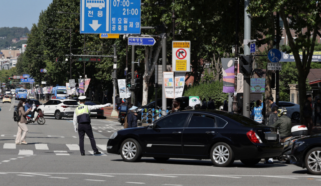 교통경찰이 12일 오후 서울 종로구 이화사거리에서 우회전 차량을 단속하고 있다. 연합뉴스
