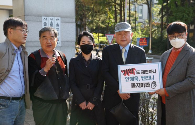 윤석열 대통령 부인 김건희 여사가 과거 유흥주점에서 일했다는 이른바 '쥴리 의혹'을 제기한 안해욱 전 대한초등학교태권도협회장(맨 오른쪽) 등이 13일 오전 서울중앙지법에서 열리는 1심 1회 공판준비기일에 출석하기 전 카메라 앞에 서 있다. 연합뉴스