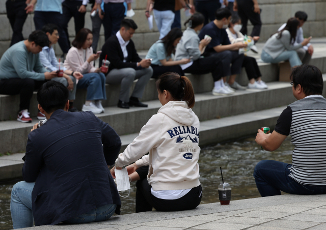 지난달 26일 점심시간 청계천을 찾은 직장인들 대부분이 마스크를 벗고 휴식을 취하고 있다. 연합뉴스