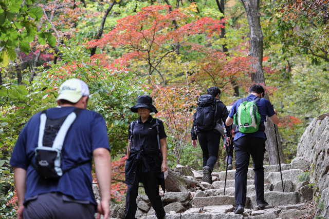 16일 오전 서울 강북구 북한산국립공원을 찾은 등산객들이 단풍이 붉게 물든 산을 오르고 있다. 연합뉴스