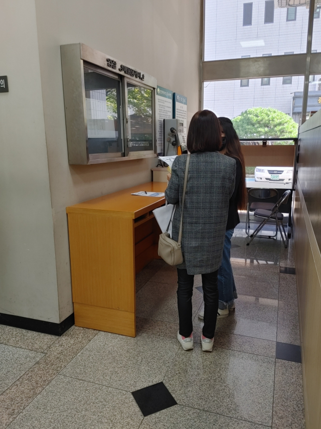 지난 13일 서울 신정동 서울남부지법 경매법정을 찾은 이들이 매각절차가 진행되는 동안 게시판을 둘러보고 있다. 김연하기자