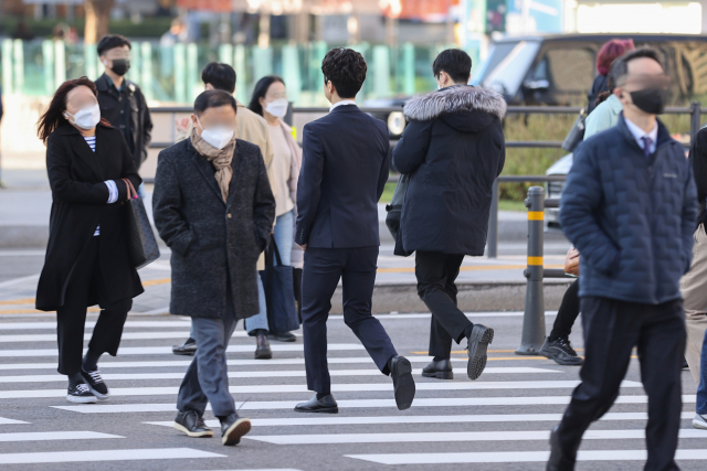 서울 아침 기온이 7도까지 떨어지며 초겨울 날씨를 보인 12일 오전 서울 종로구 광화문역 인근에서 시민들이 길을 건너고 있다. 연합뉴스