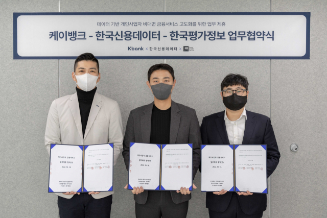 김민찬(왼쪽부터) SME CAMP장, 신서진 한국신용데이터 이사, 이민제 한국평가정보 이사가 지난 18일 한국신용데이터 본사에서 개인사업자 비대면 금융서비스 고도화를 위한 업무협약(MOU)을 체결한 뒤 협약서를 들어보이고 있다. 사진 제공=케이뱅크