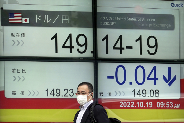 19일 일본 도쿄에서 한 남성이 엔달러 환율이 달러당 149엔을 넘었다는 시황을 보여주는 전광판 앞을 지나가고 있다. AP연합뉴스