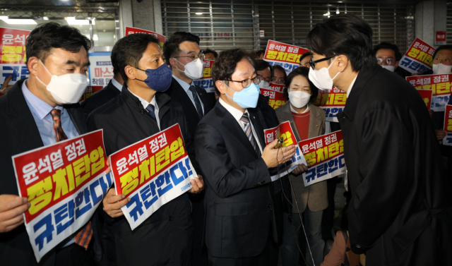 박범계 더불어민주당 의원이 19일 서울 여의도 중앙당사 앞에서 민주연구원 압수수색에 나선 검찰 관계자들과 대치하던 중 대화를 시도하고 있다. 권욱 기자